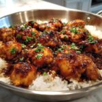 Glazed chicken pieces served over white rice in a stainless steel skillet, featuring the Honey Garlic Chicken Skillet with Rice.