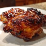 Close-up of a perfectly cooked Honey Soy Chicken Thighs with crispy, caramelized edges and a shiny glaze.
