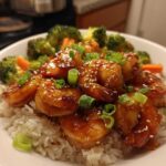 Close-up of a Honey Soy Shrimp Bowl with rice, topped with glossy glazed shrimp, sesame seeds, and green onions.