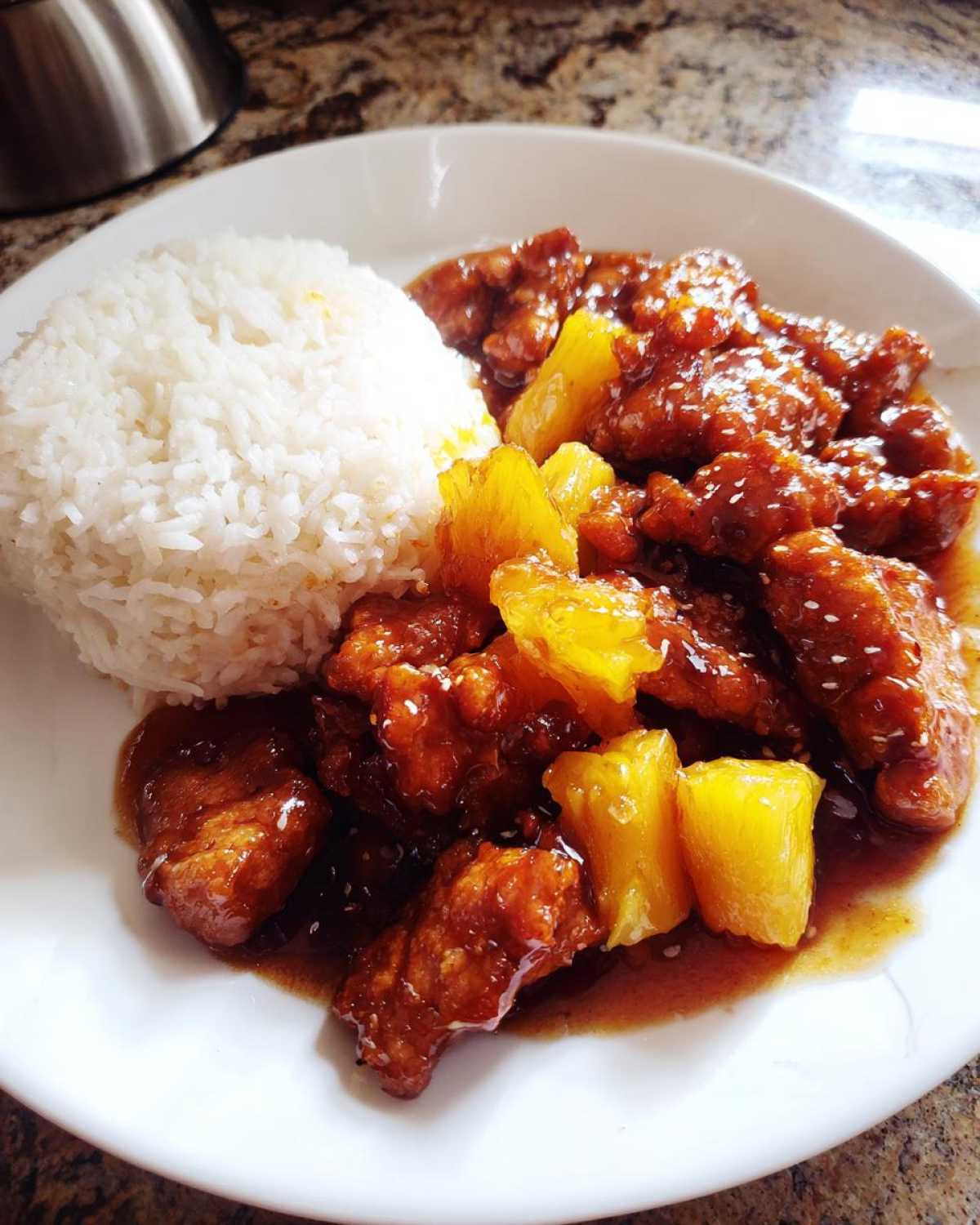 A plate featuring Sticky Pineapple Chicken with Sweet Glaze served alongside white rice.