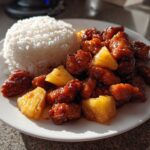 A plate of Sticky Pineapple Chicken with Sweet Glaze served next to a mound of white rice.
