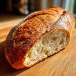 Close-up of a freshly baked Bakery Style French Bread showing its crackly, golden-brown crust and open crumb structure.