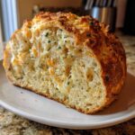Cross section of Bread Machine Italian Herb Bread Loaded with Cheese and Garlic showing melted, stringy cheese and herbs.