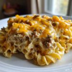 A generous serving of Cheesy Hamburger Casserole featuring ground beef, creamy sauce, and melted cheddar cheese over egg noodles.