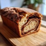 A freshly baked Cinnamon Sugar Donut Bread loaf showing a beautiful swirl of cinnamon filling inside.