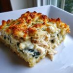 Close-up of a serving of Creamy Chicken and Spinach Casserole with a golden, cheesy crust.