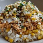 A close-up of the Flavor Street Corn Chicken Rice Bowl featuring shredded chicken, corn, cotija cheese, and cilantro over white rice.