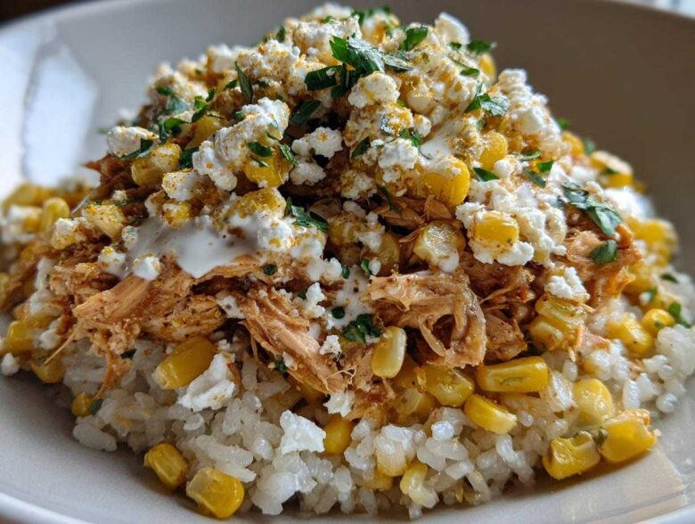 A close-up of the Flavor Street Corn Chicken Rice Bowl featuring shredded chicken, corn, cotija cheese, and cilantro over white rice.