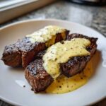 Two perfectly seared steaks topped with rich Parmesan Cream Sauce, ready to eat.