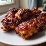 Close-up of crispy chicken wings heavily coated in a thick, glossy Honey Garlic Chicken glaze.