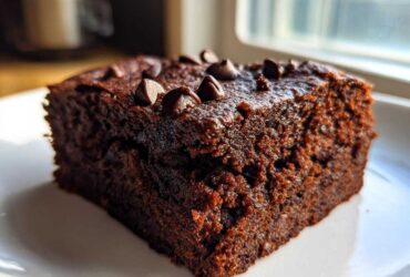 A close-up, moist slice of rich chocolate Banana Bread Brownies topped with melted chocolate chips.