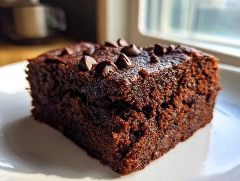 A close-up, moist slice of rich chocolate Banana Bread Brownies topped with melted chocolate chips.