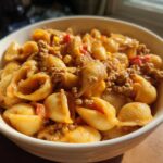 Close-up of a creamy bowl of One Pot Taco Pasta featuring shell pasta, seasoned ground meat, and corn.
