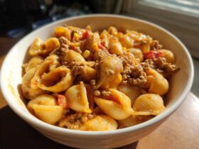 Close-up of a creamy bowl of One Pot Taco Pasta featuring shell pasta, seasoned ground meat, and corn.