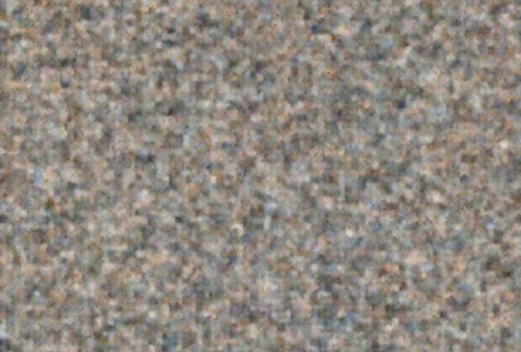 Abstract, grainy background texture, possibly representing a countertop or surface near the Strawberry Shortcake.