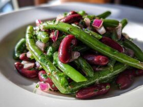 Close-up of a vibrant Bean Salad featuring bright green beans, deep red kidney beans, and chopped red onion.
